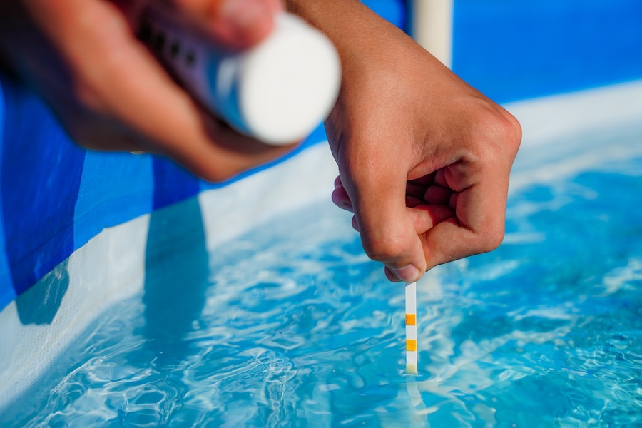 Checking the water quality of a pool with the help of a test strip with PH value