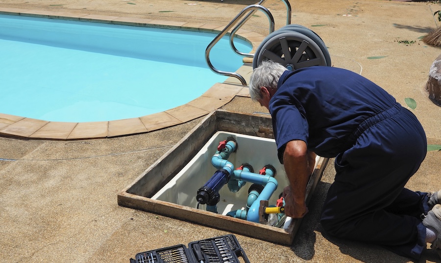 echnician fixing swimming pool water pump.