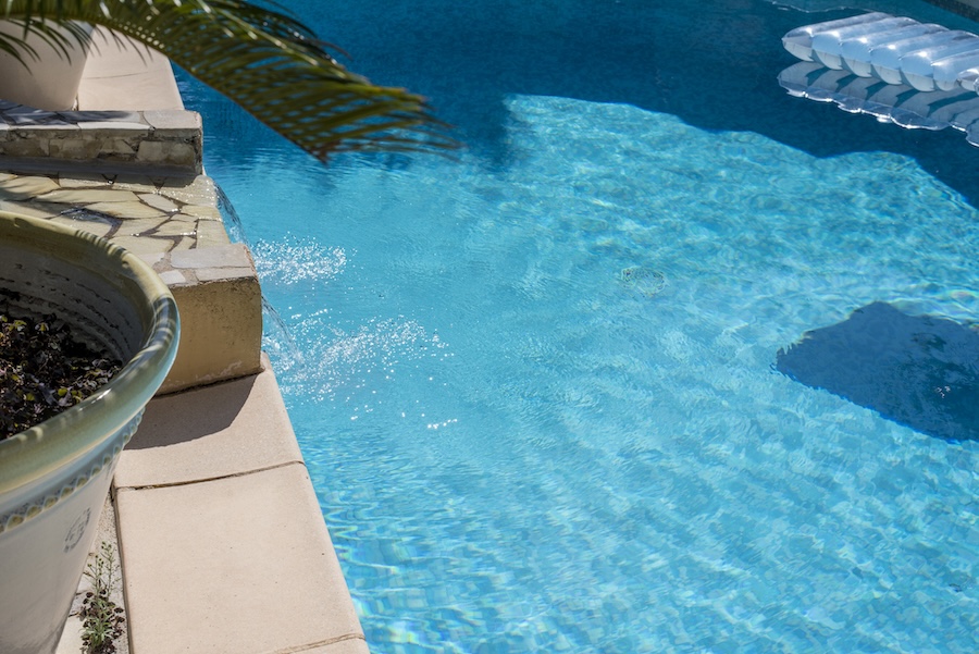 View on blue swimming pool with a waterfall