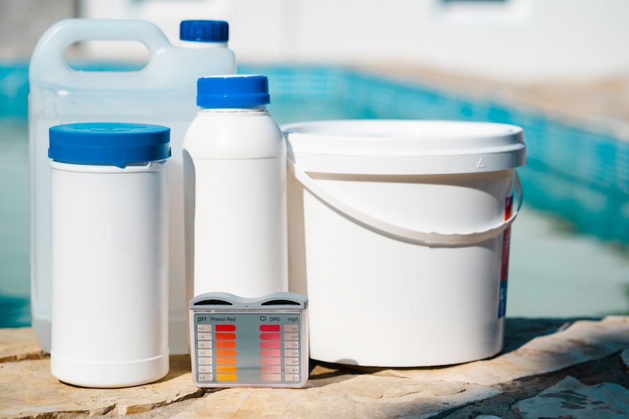 Equipment for testing the quality of pool water and chemical cleaning products at the edge of swimming pool.