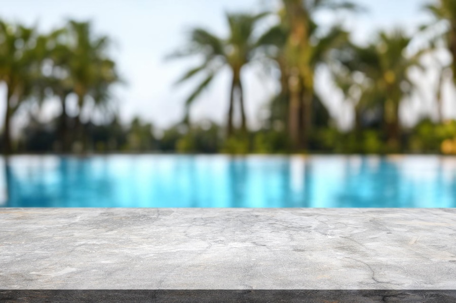 Table or surface with tropical swimming pool or beach in the background