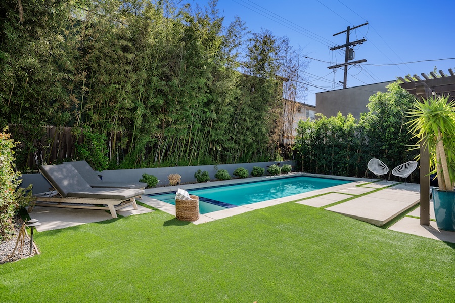 A backyard pool with lush greenery