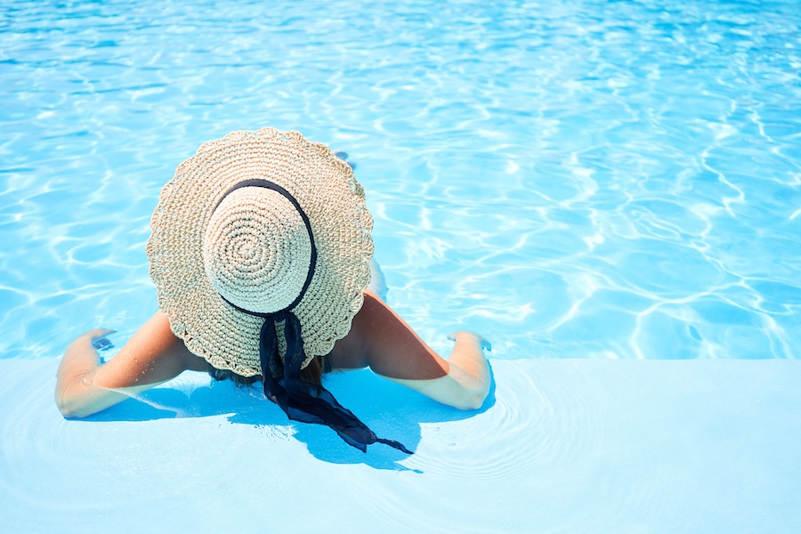 Young beautiful and sexy woman at swimming at resort pool on vacation
