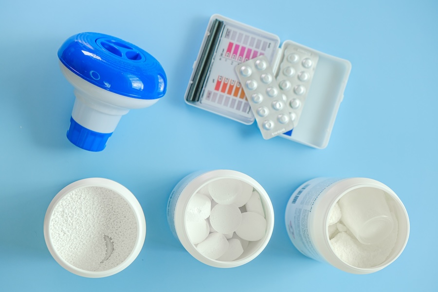 Pool cleaning equipment and chemicals on a blue background