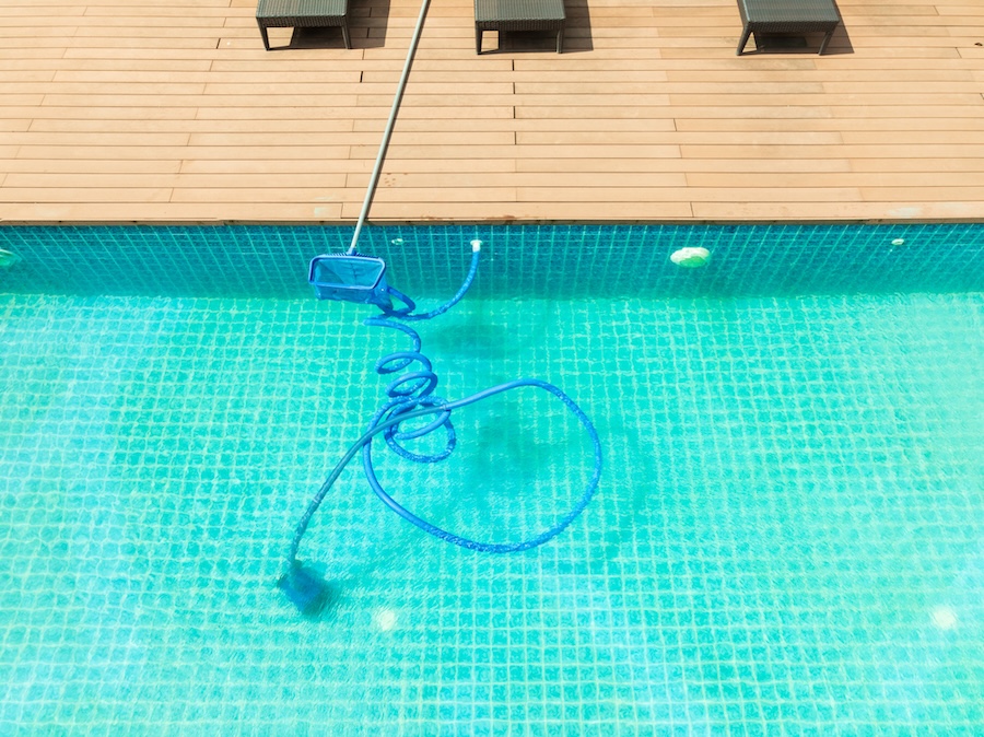 Pool maintenance with scoop net and automatic robot cleaner.