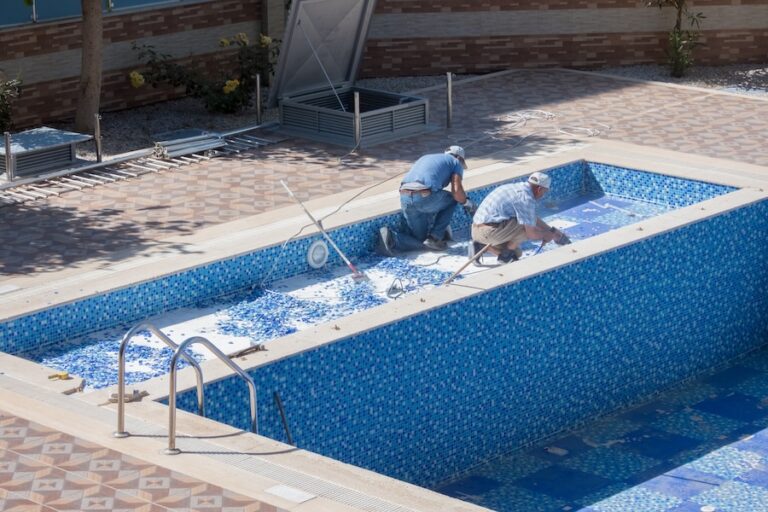 Two workers repairing a swimming pool