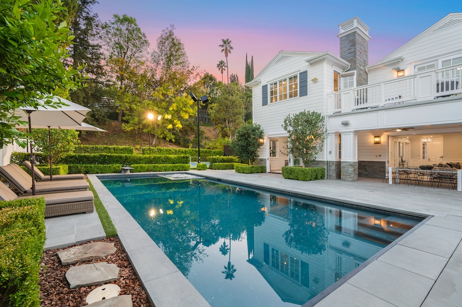 A swimming pool in front of a new construction home