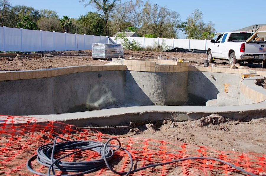 A residential swimming pool in the process of being built with bare concrete walls 