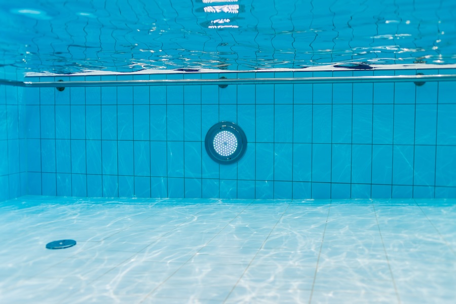 Clean blue water in a swimming pool, view from under the water