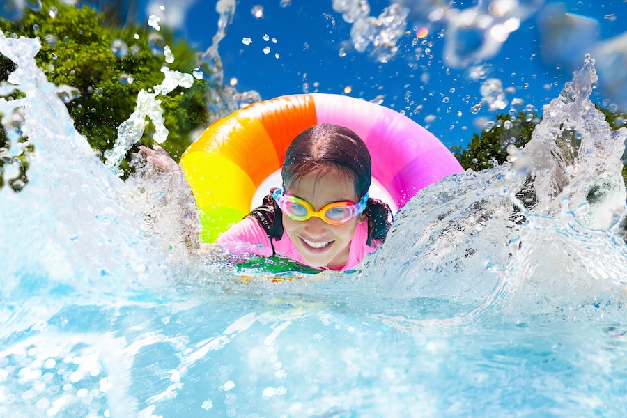 Child in swimming pool floating on toy ring