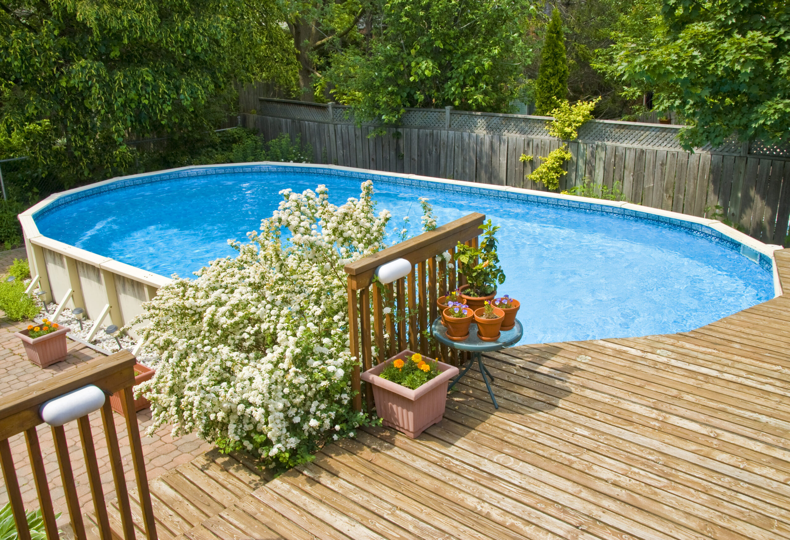 an above ground pool with a wood deck around it
