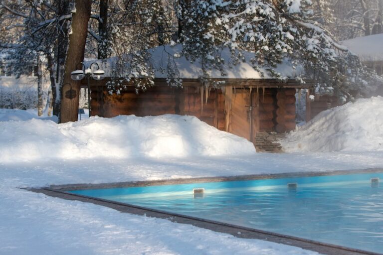 Warm swimming pool with blue water in sunny winter weather, outdoor.