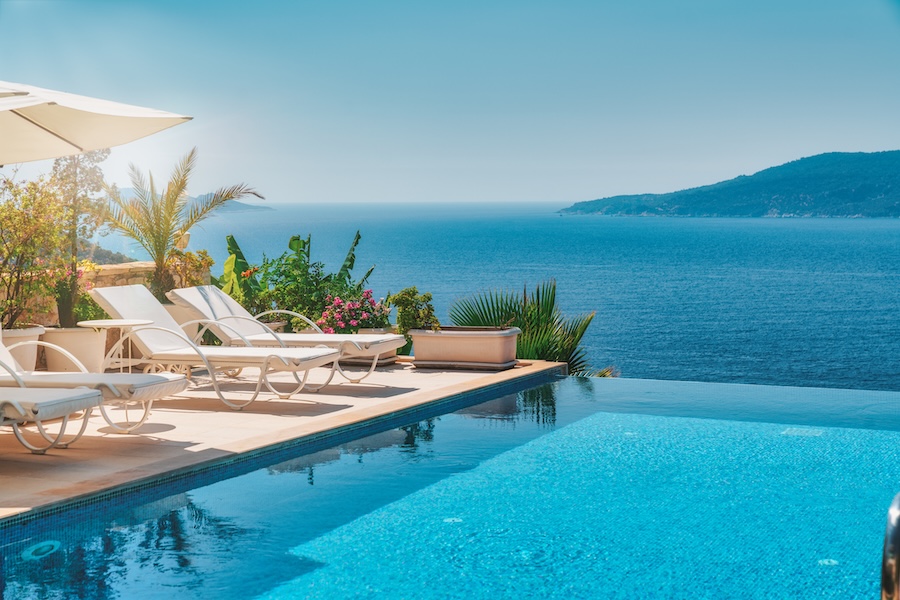 infinity pool overlooking the ocean with pool chairs