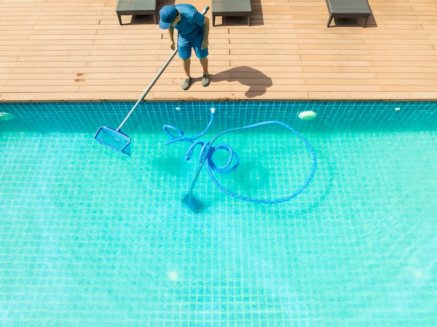 Pool maintenance with scoop net and automatic robot cleaner.