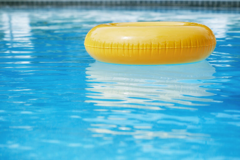 floating ring on blue water swimpool with waves reflecting in the summer sun